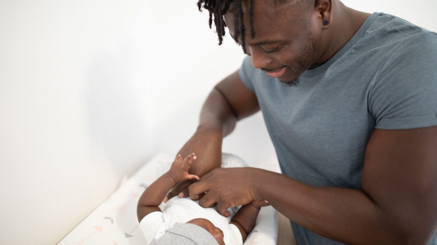 man-touching-his-baby-while-lying-on-white-pad-3536632